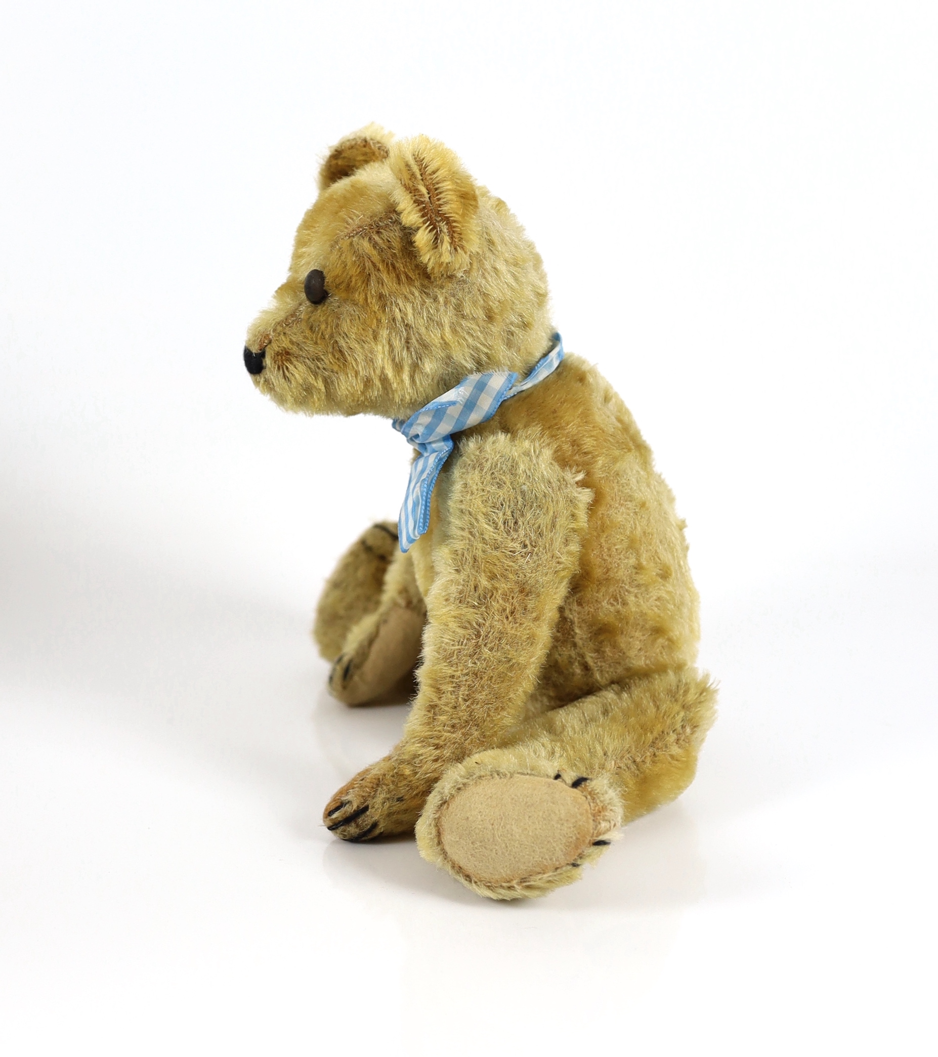 An early German bear, c.1920, with set in ears, black button eyes, 35cm, replaced paw pads, otherwise good condition